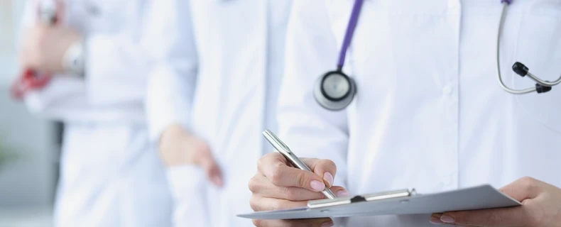 doctor using pen and clipboard