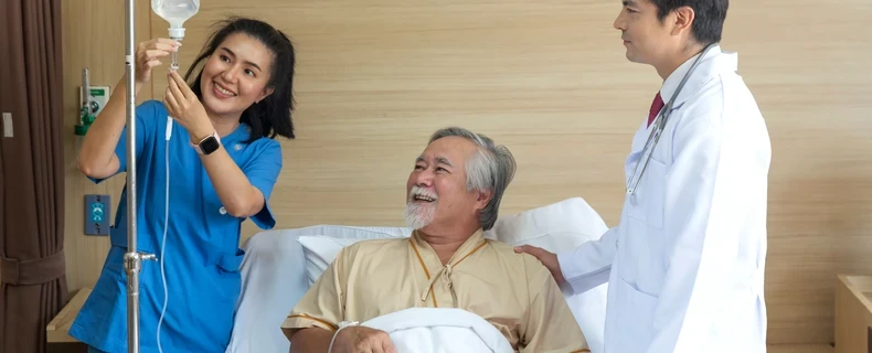 Doctor and patient in hospital adjusting IV pole