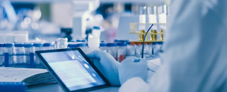 Clinician using an iPad and clinical technology during research in lab